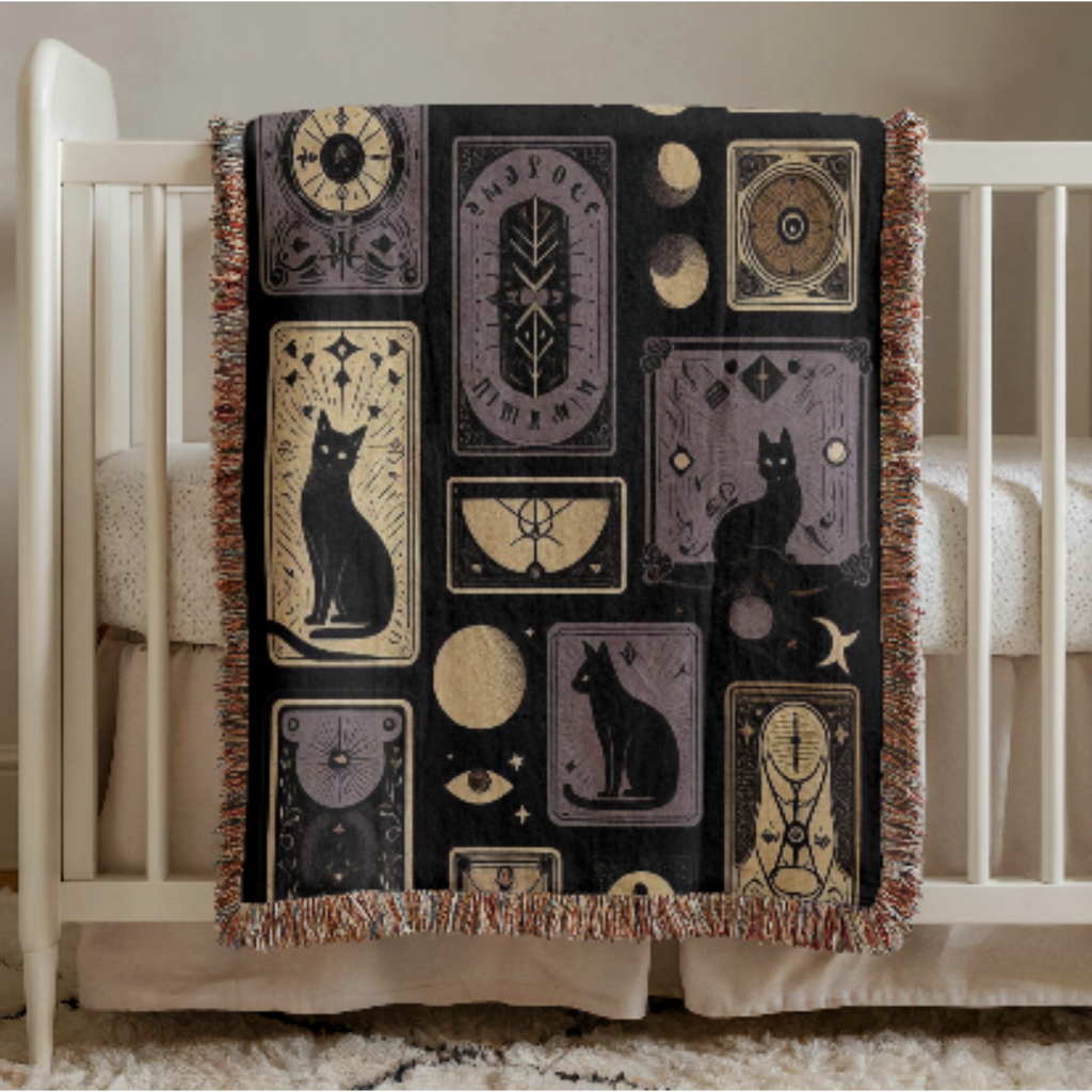 Black Cat Gothic Woven Baby Blanket with black cat and geometric patterns draped over a crib.