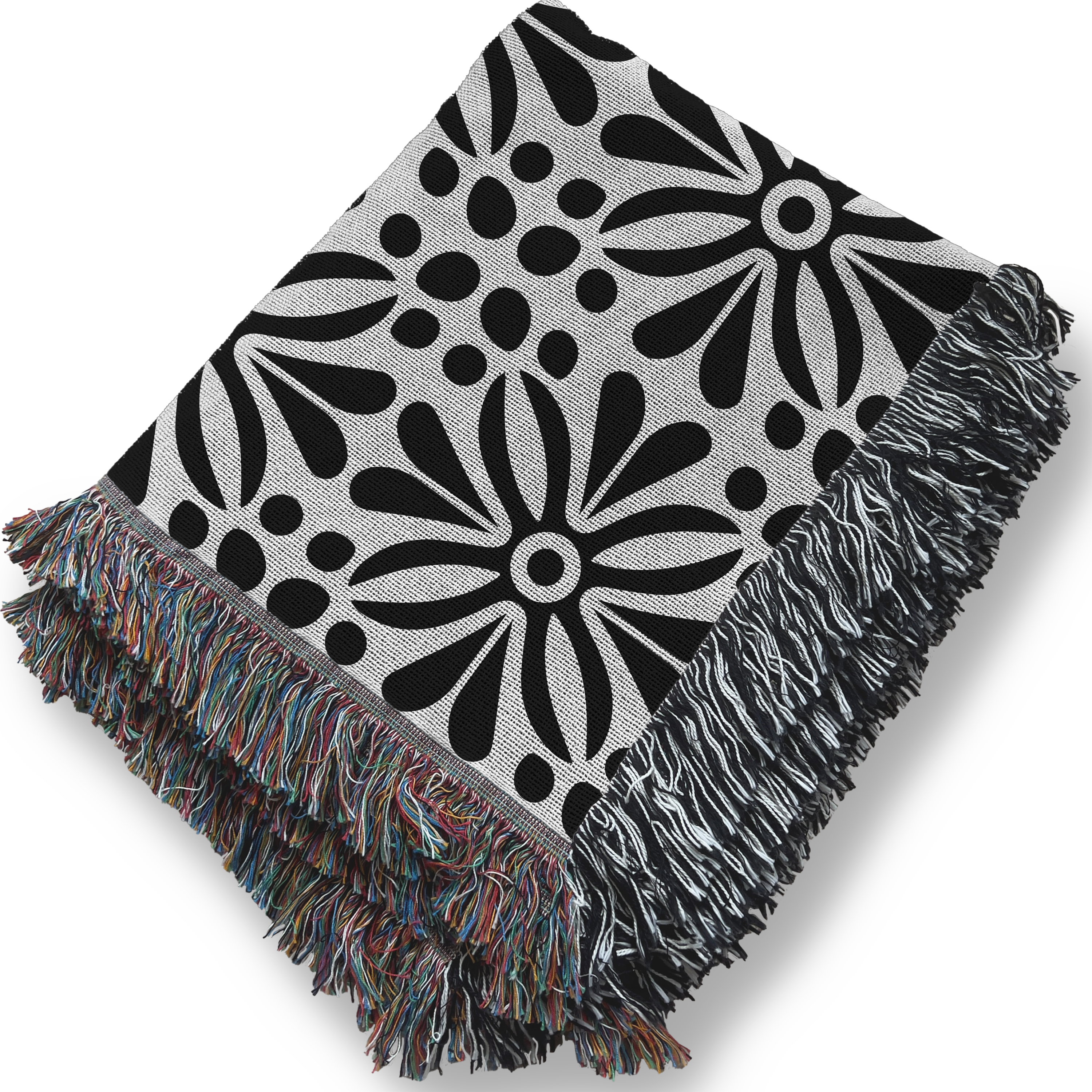 Black and white floral patterned throw blanket with colorful fringe on a white background