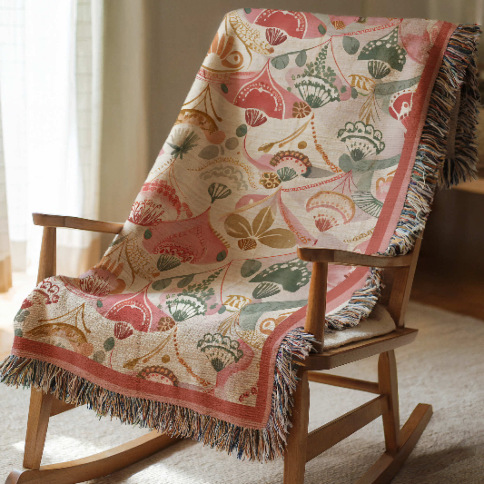 Pink Boho Woven Blanket with a floral pattern draped over a wooden rocking chair.