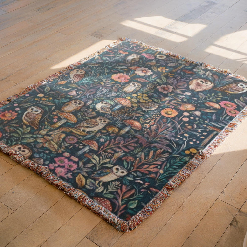 Decorative blanket with floral and owl pattern on a wooden floor