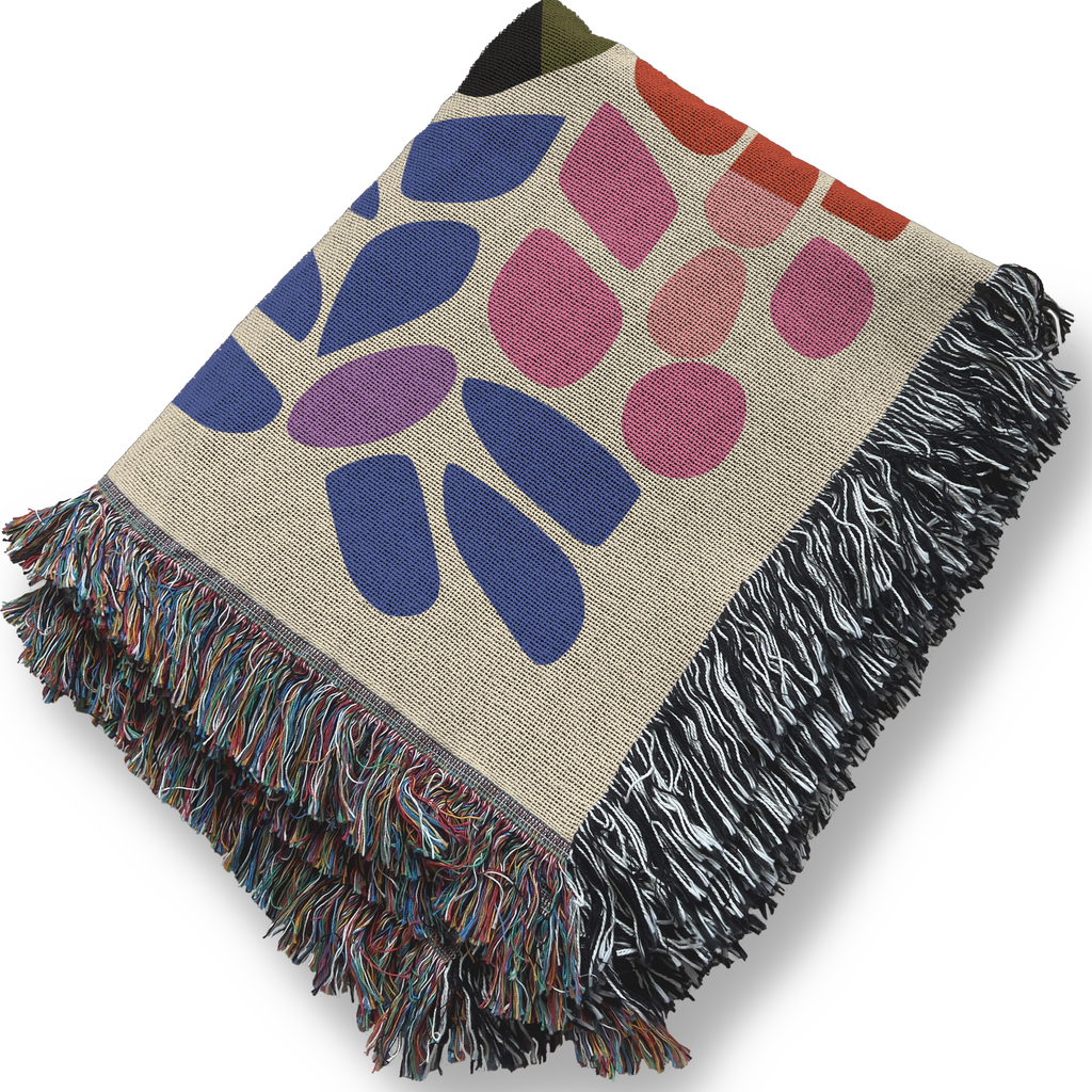 Colorful rainbow patterned blanket with fringe on a white background