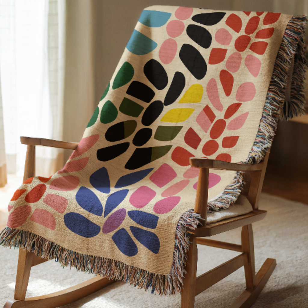 Colorful patterned blanket draped over a wooden rocking chair.