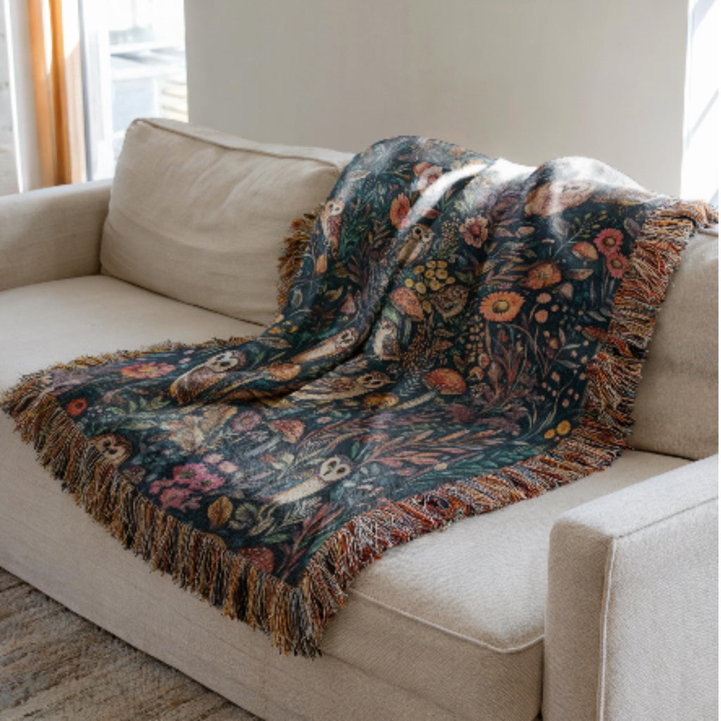 Floral patterned blanket draped over a beige sofa in a living room.