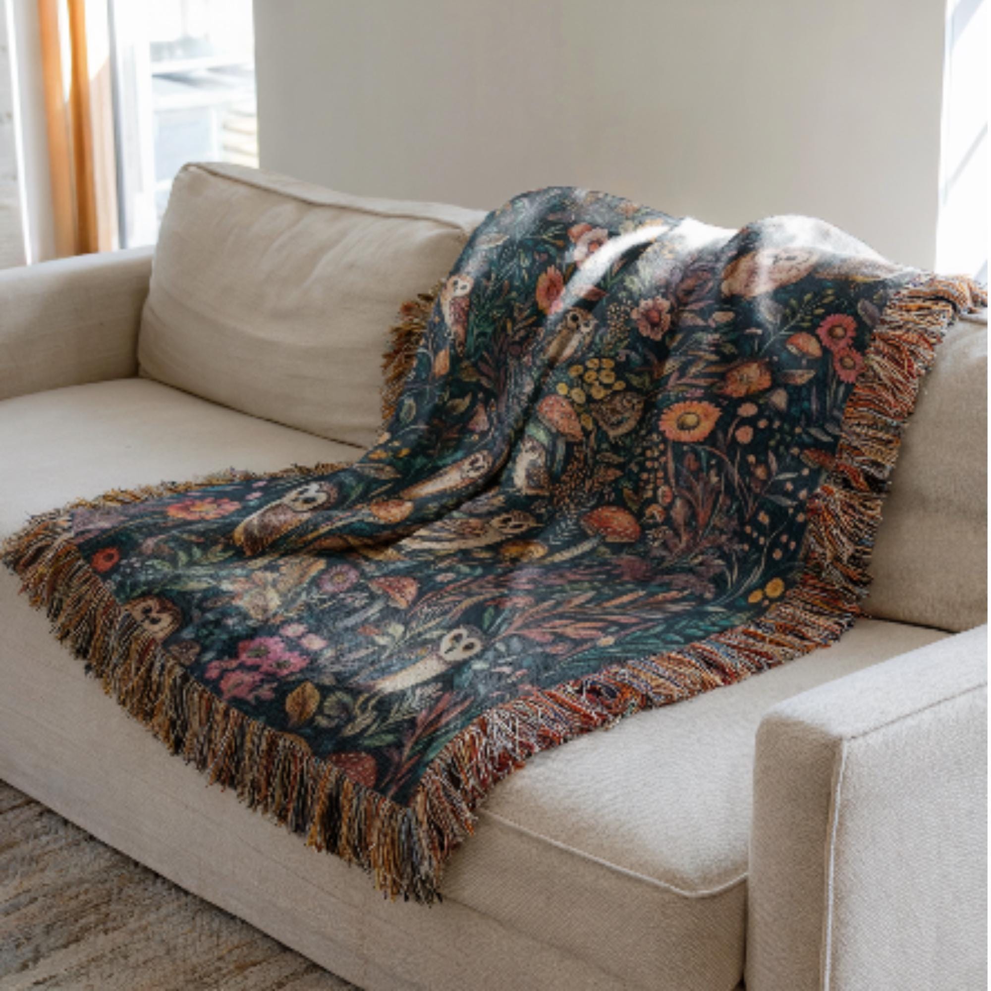 Floral patterned blanket draped over a beige sofa in a living room.